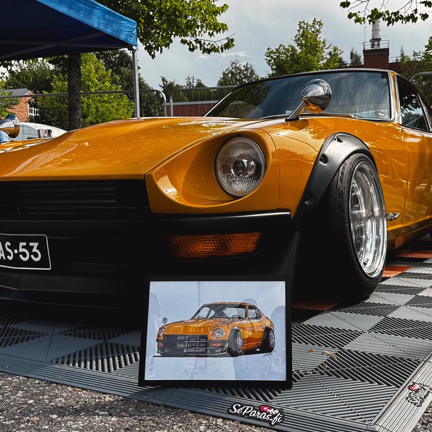 Yellow sports car on a checkered platform with a smaller inset image of the car.
