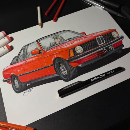 Colorful drawing of a red car on paper with art supplies around