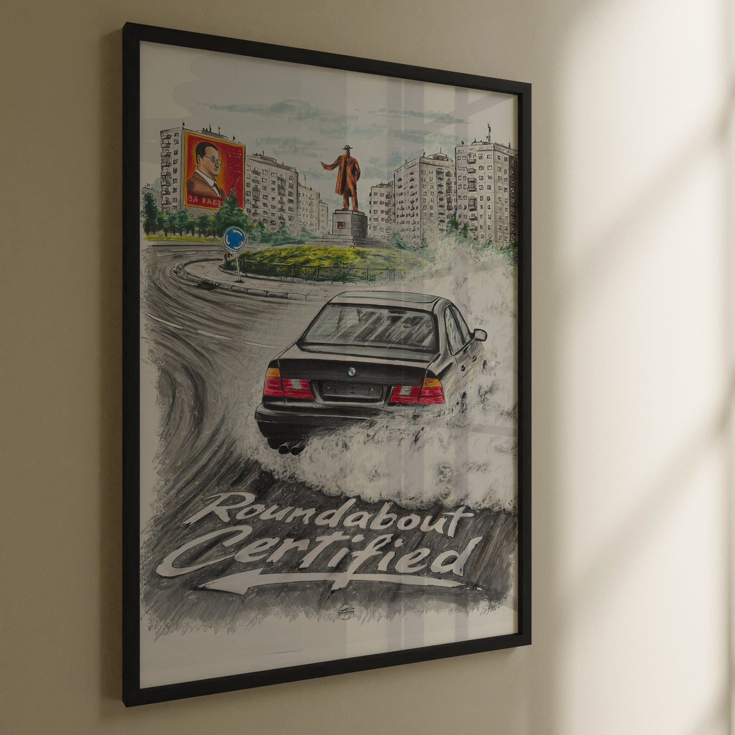 Framed artwork of a bmw e34 poster with text 'Roundabout Certified' on a wall.