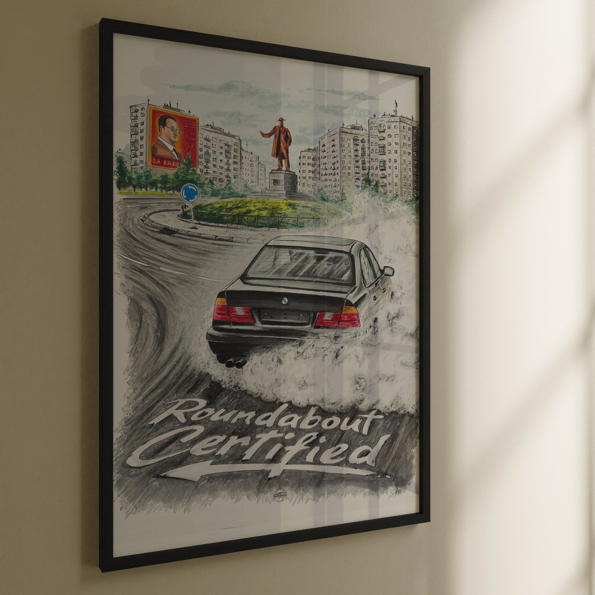 Framed artwork of a bmw e34 poster with text 'Roundabout Certified' on a wall.