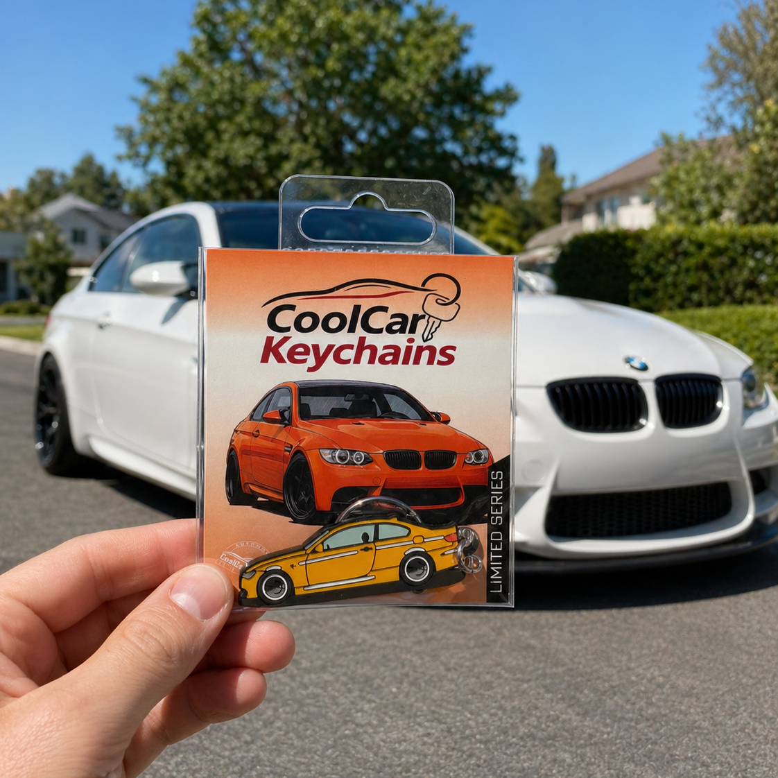 Packaging of CoolCar Keychains held in front of a white BMW car on a sunny day.