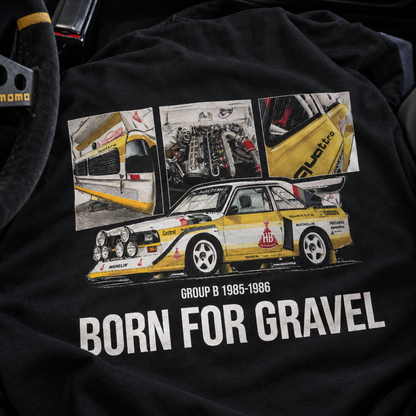 A close-up of a black hoodie featuring a large graphic print of a Audi Quattro Group B race car with three inset photos above it. The text 'GROUP B 1985-1986' and 'BORN FOR GRAVEL' are printed in white below the car.
